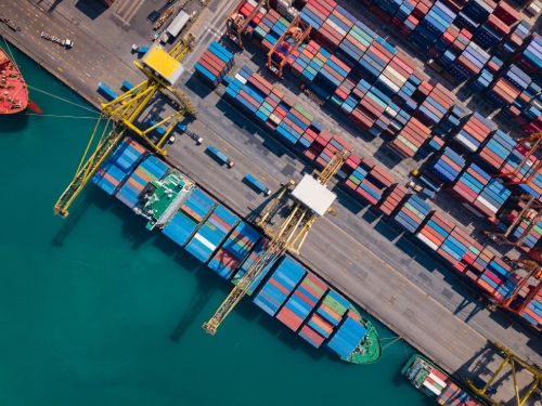 aerial view of busy container terminal and cargo cranes
